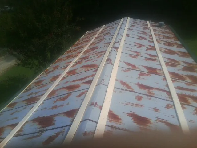 Rusted metal roof panels with new wood purlins before replacement — Storm Damage Roof Repair in Pineview by Roofing Brothers